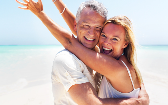 Happy middle aged couple enjoying beach vacation